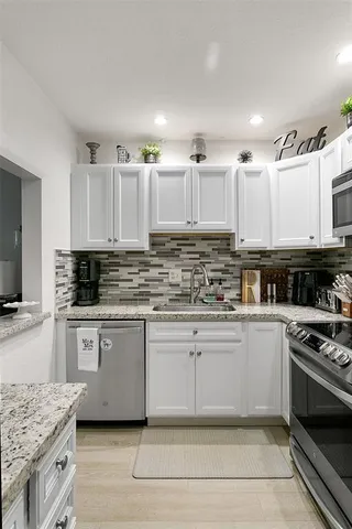 a kitchen with stainless steel appliances granite countertop a stove and cabinets