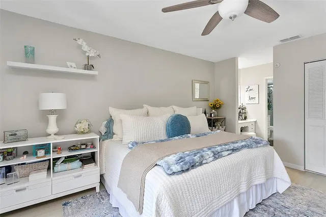 a bedroom with a bed and a lamp on dresser