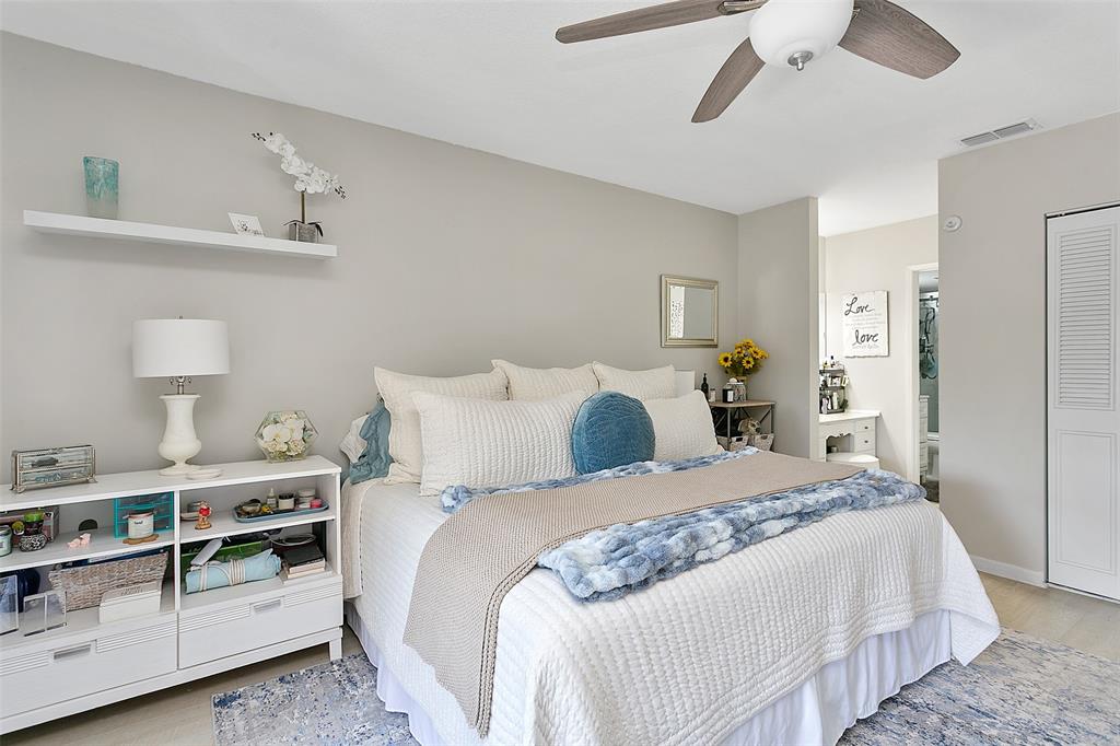 259 South Cypress Road, Unit 546 Pompano Beach, FL 33060 - Photo 13 of 23 a bedroom with a bed and a lamp on dresser