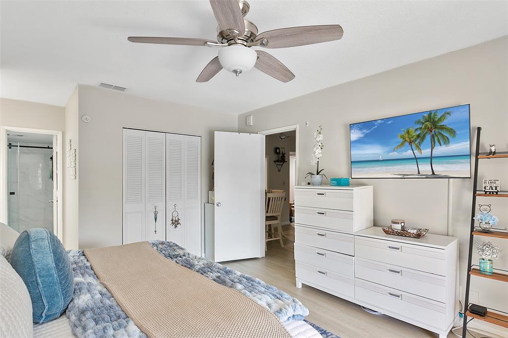 259 South Cypress Road, Unit 546 Pompano Beach, FL 33060 - Photo 14 of 23 a bedroom with a bed and a chandelier