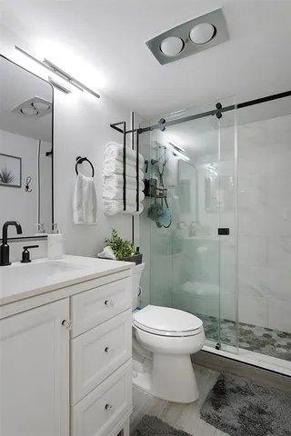 a bathroom with a sink a toilet and shower