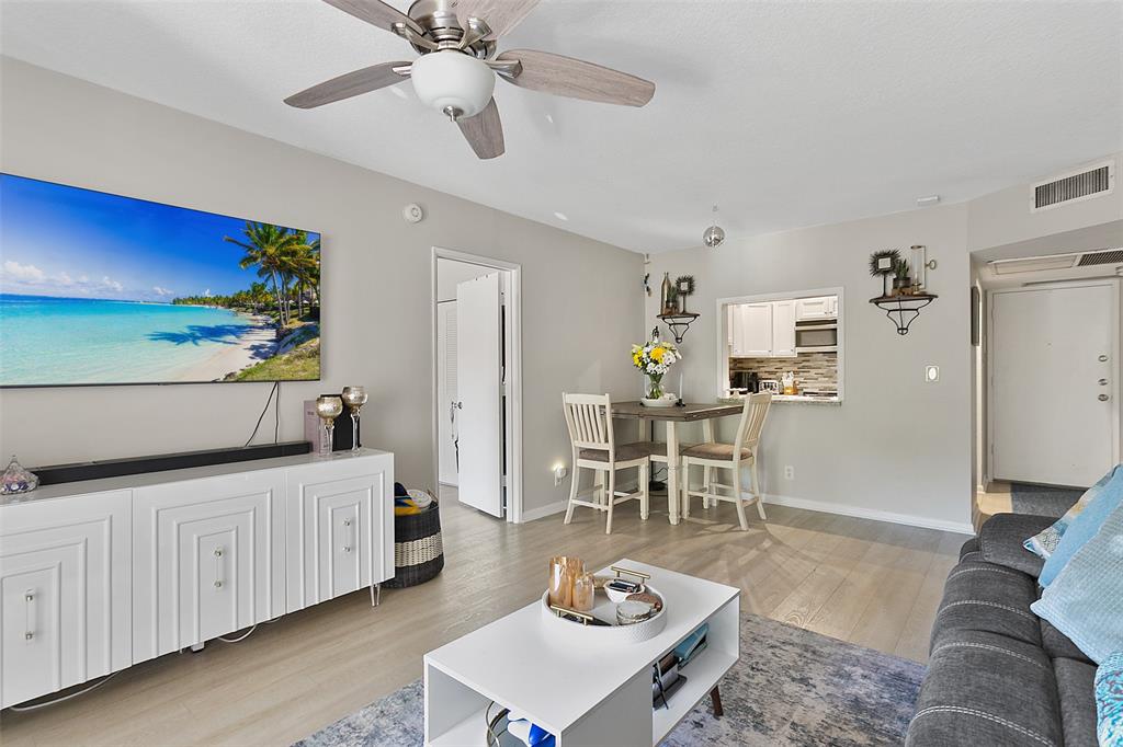 259 South Cypress Road, Unit 546 Pompano Beach, FL 33060 - Photo 8 of 23 a living room with furniture and a dining table with wooden floor