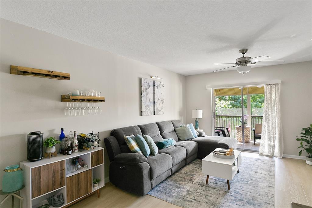 259 South Cypress Road, Unit 546 Pompano Beach, FL 33060 - Photo 9 of 23 a living room with furniture a potted plant and a large window