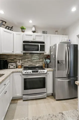 a kitchen with stainless steel appliances and granite countertop a stove top oven