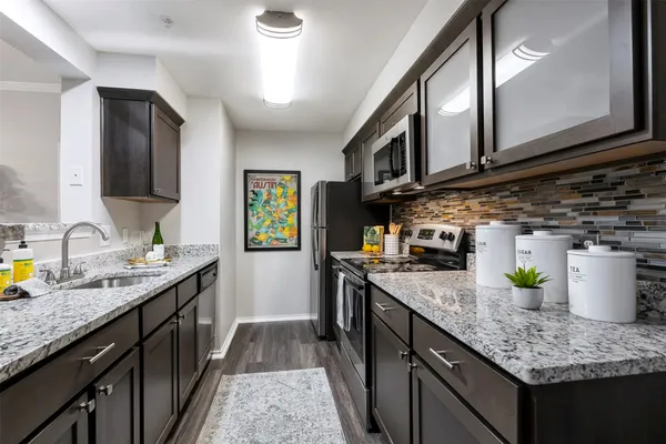 a kitchen with stainless steel appliances granite countertop a sink stove and cabinets