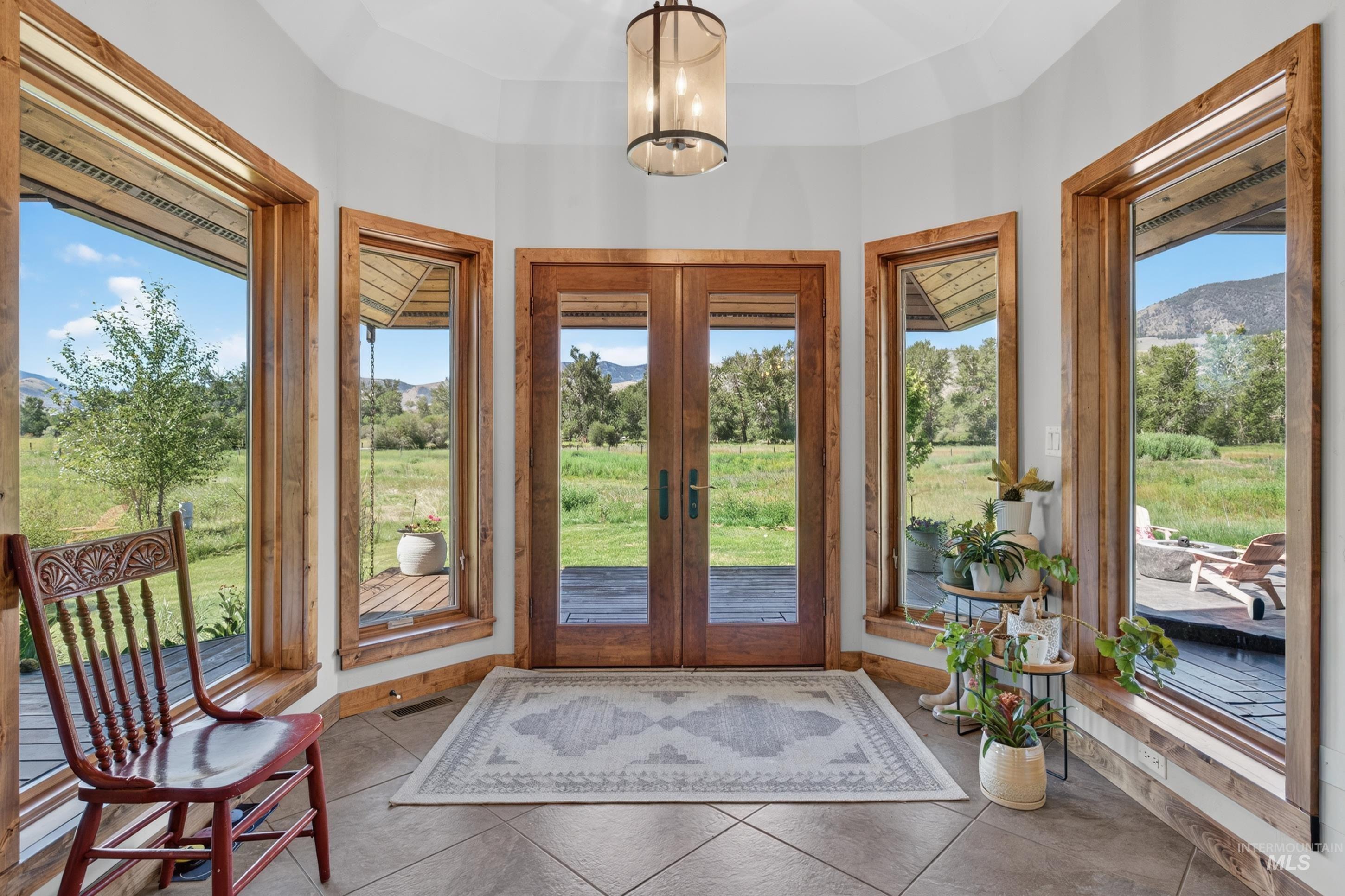 63 Mountain View Road Salmon, ID 83467 - Photo 21 of 50 Tiled entryway with natural wood-framed windows and a double glass-panel door