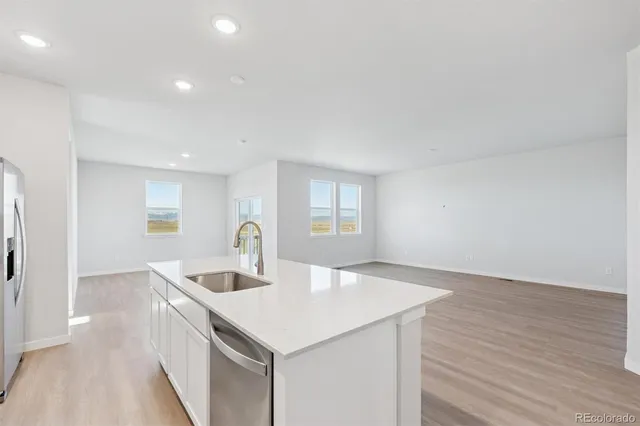 a kitchen with a sink and wooden floor