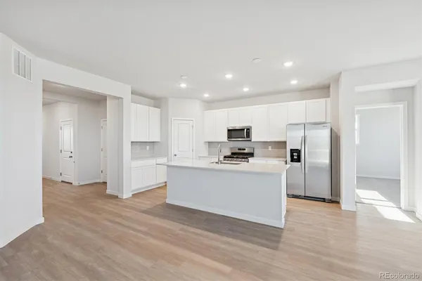 a kitchen with stainless steel appliances a refrigerator sink and cabinets