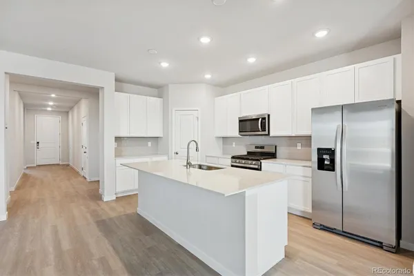 a kitchen with stainless steel appliances a refrigerator stove microwave and sink