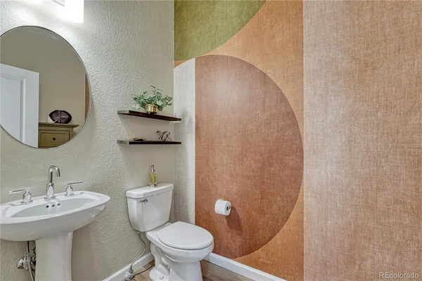 a bathroom with a toilet a sink and mirror