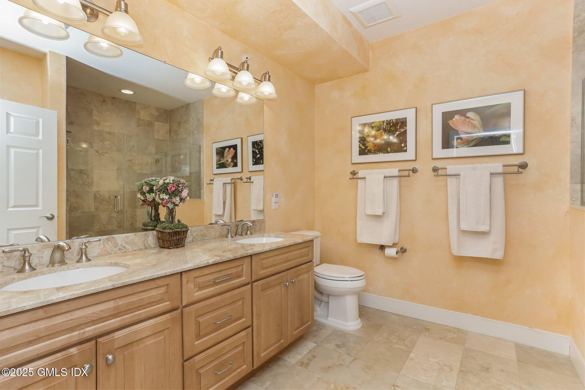 77 Havemeyer Lane, Unit 426 Stamford, CT 06902 - Photo 13 of 23 a bathroom with a double vanity sink a toilet and a mirror