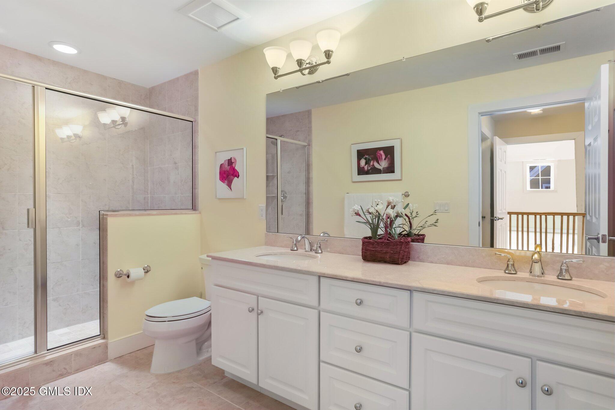 77 Havemeyer Lane, Unit 426 Stamford, CT 06902 - Photo 17 of 23 a bathroom with a granite countertop sink a toilet and a mirror