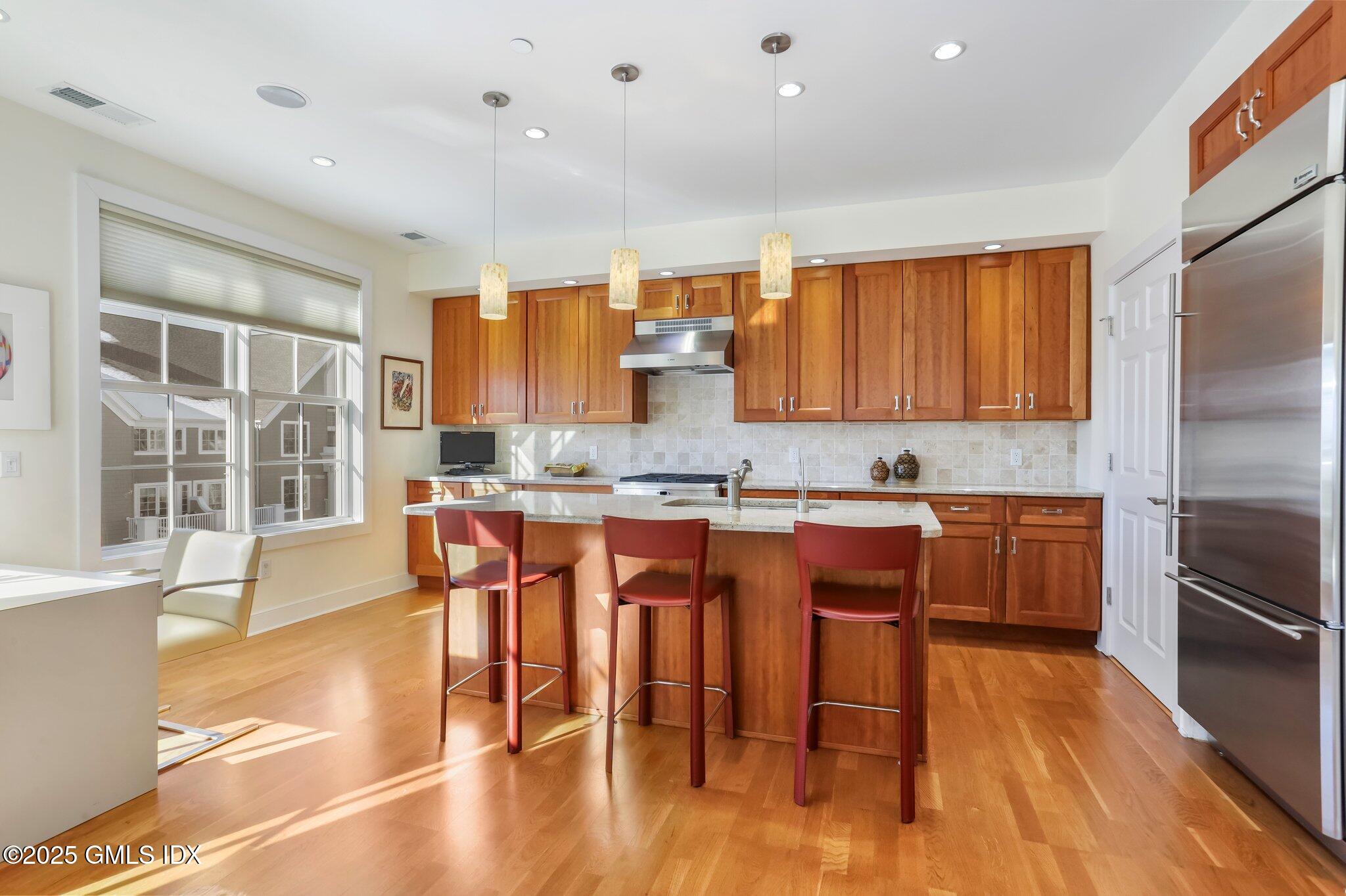 77 Havemeyer Lane, Unit 426 Stamford, CT 06902 - Photo 7 of 23 a large kitchen with a table and chairs in it
