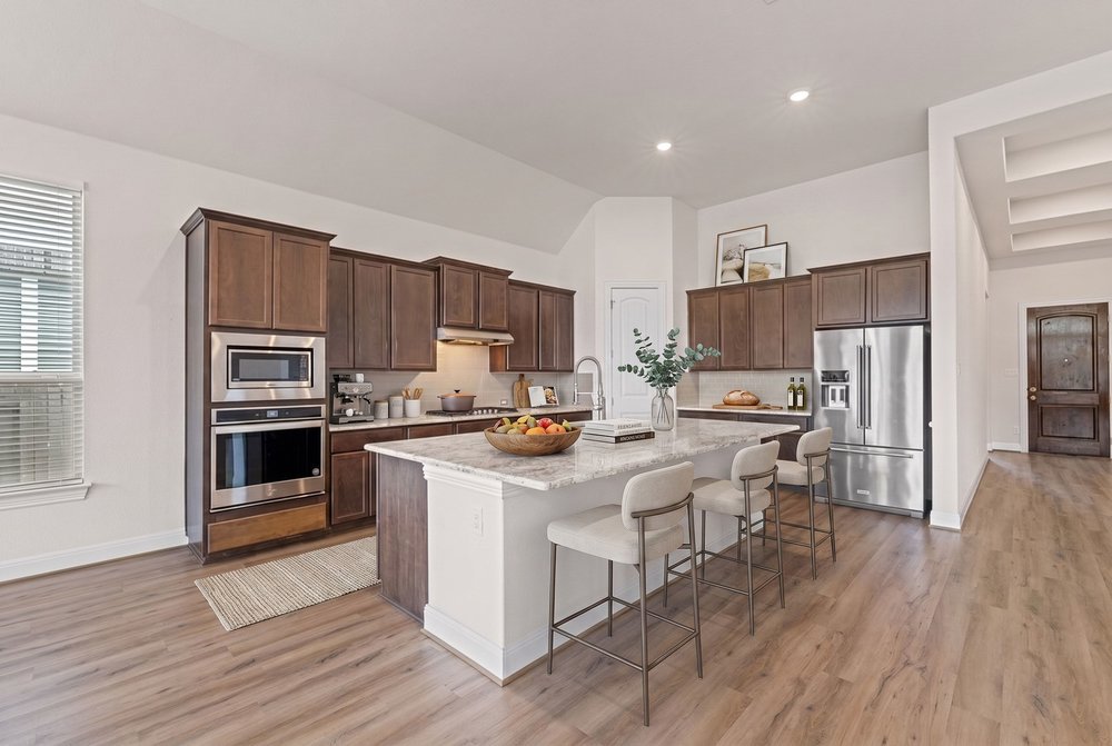 Rich wood cabinetry contrasts beautifully with granite countertops in this culinary workspace.