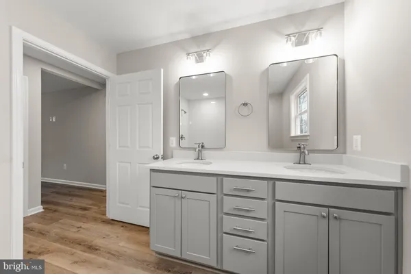 a bathroom with a double vanity sink and a mirror