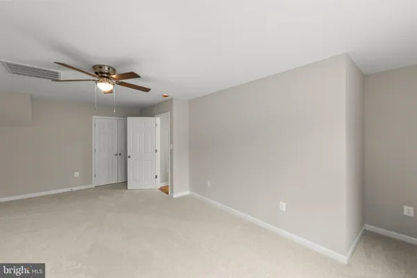 an empty room with a ceiling fan and window