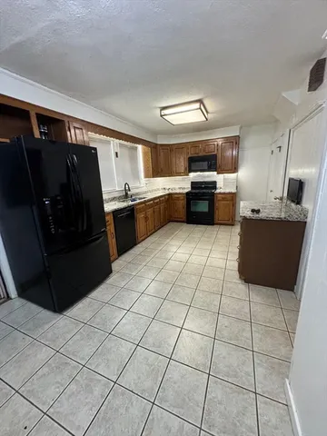 a kitchen with granite countertop a refrigerator and a sink