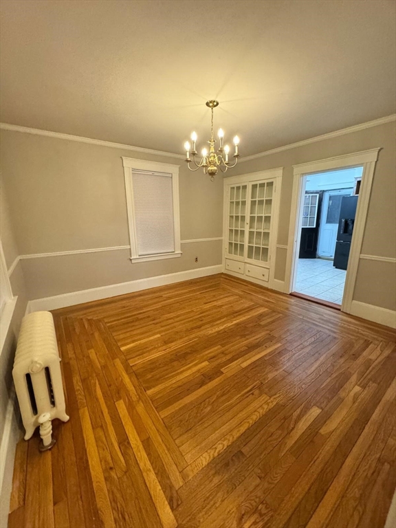 14 East Prospect Street Methuen, MA 01844 - Photo 3 of 9 an empty room with wooden floor and chandelier