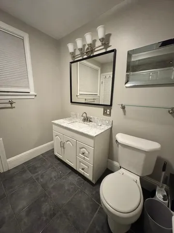 a bathroom with a toilet sink and mirror