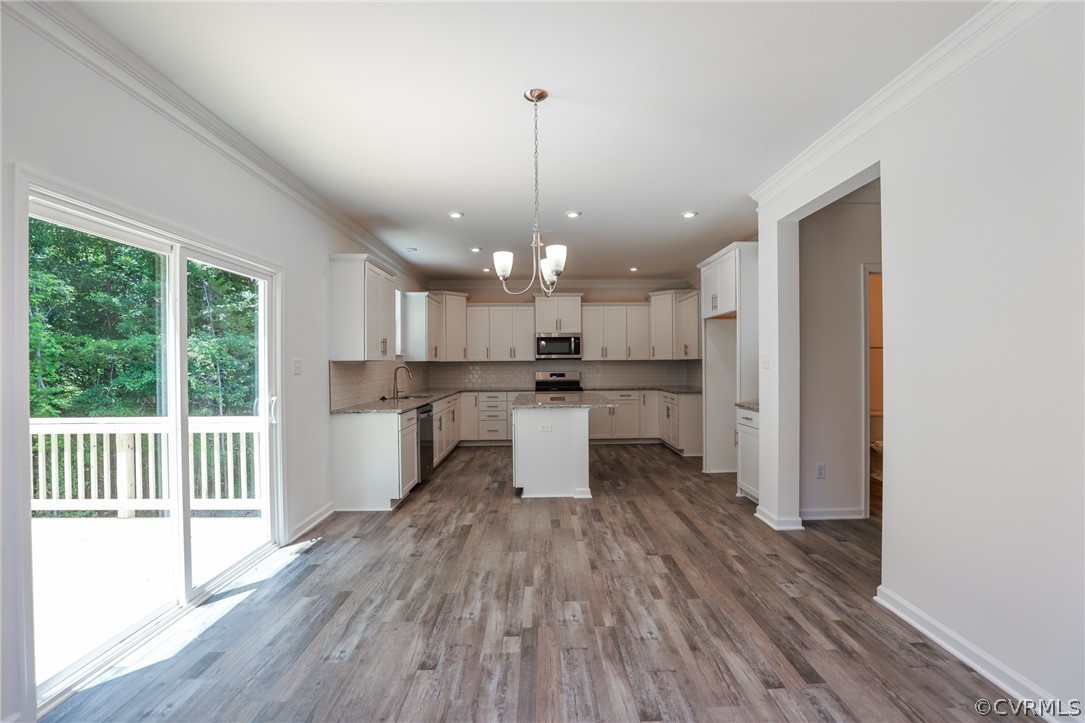 4113 Tosh Lane Chester, VA 23831 - Photo 19 of 47 a kitchen with kitchen island a wooden floor stainless steel appliances and window