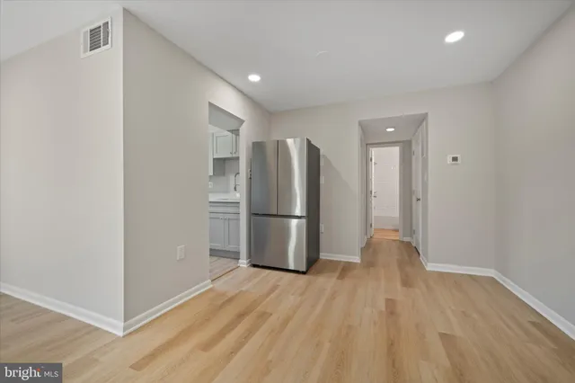 a view of a kitchen with a refrigerator and wooden floor