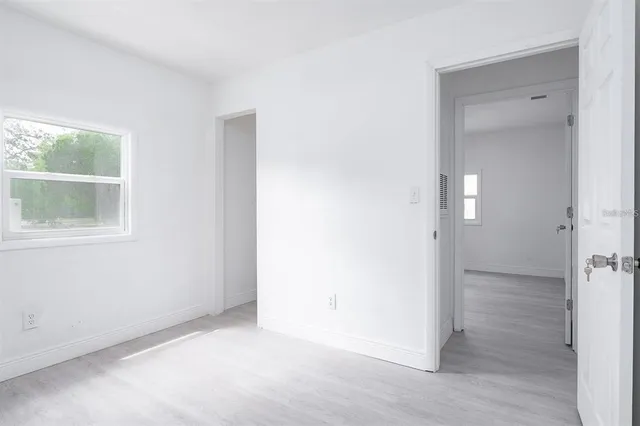 an empty room with wooden floor and a window