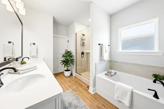 a bath room with a tub sink and mirror