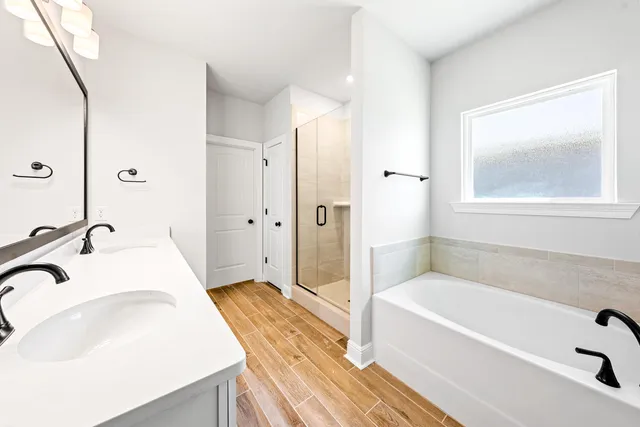 a bathroom with a tub sink and mirror