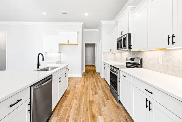 a kitchen with kitchen island granite countertop lots of counter top space and stainless steel appliances