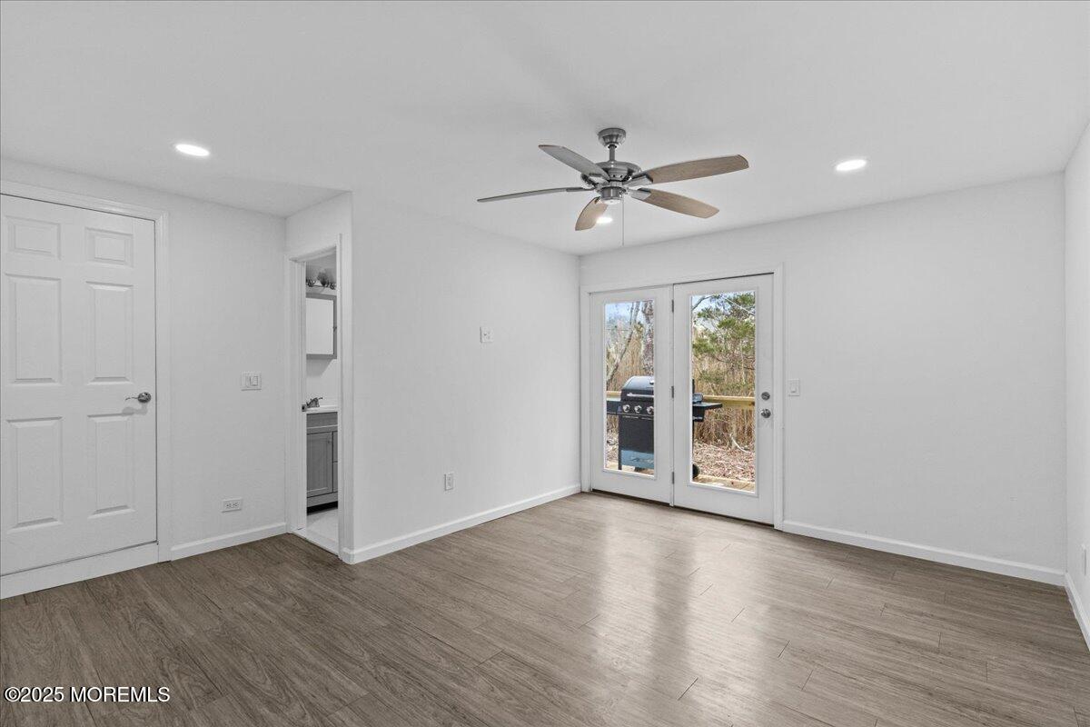 98 Marine Road Waretown, NJ 08758 - Photo 27 of 40 an empty room with wooden floor chandelier fan and windows
