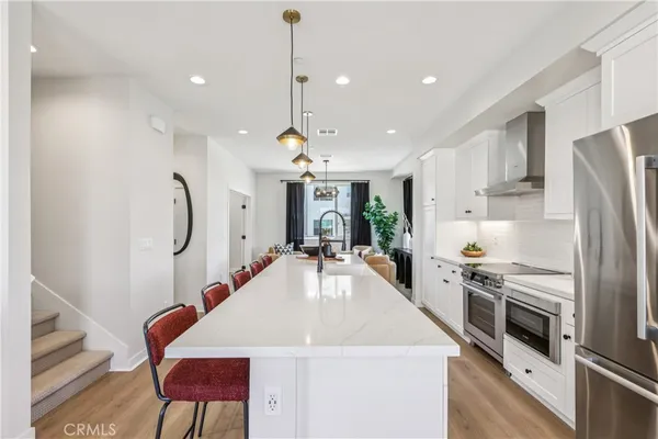 a kitchen with stainless steel appliances granite countertop a sink refrigerator and microwave