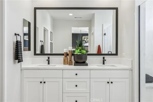 a bathroom with double sink and a mirror