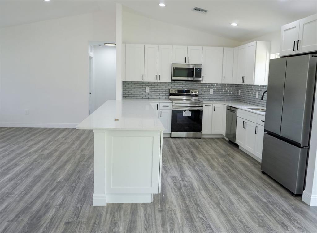136 Lincoln Road Northwest Lake Placid, FL 33852 - Photo 4 of 31 a kitchen with stainless steel appliances a refrigerator stove microwave and cabinets