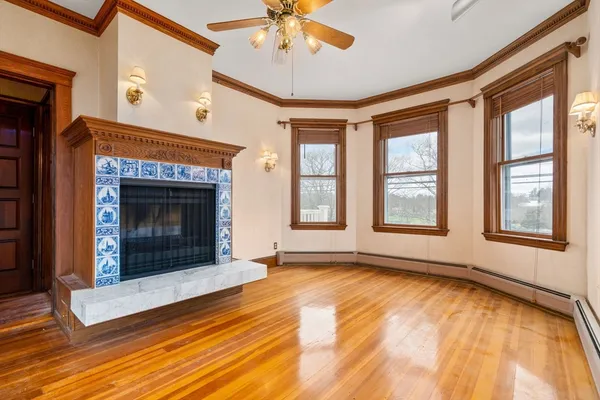 a view of an empty room with window and fire place