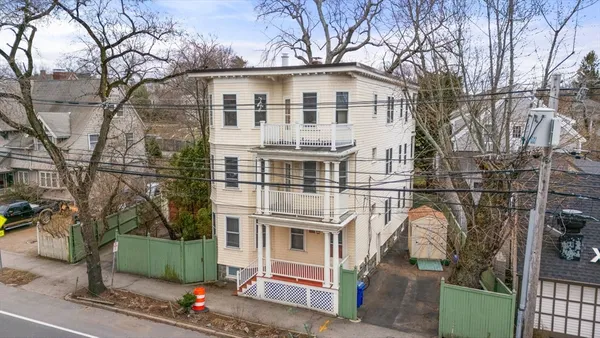 a front view of a house with a tree