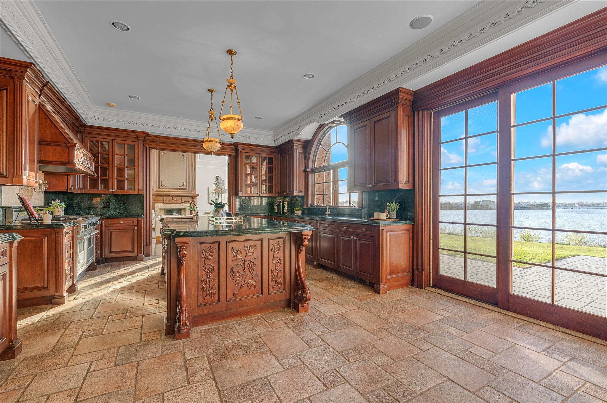 3 Point Crescent Queens, NY 11357 - Photo 16 of 38 Kitchen with a water view, stone tile floors, decorative backsplash, glass insert cabinets, and ornamental molding