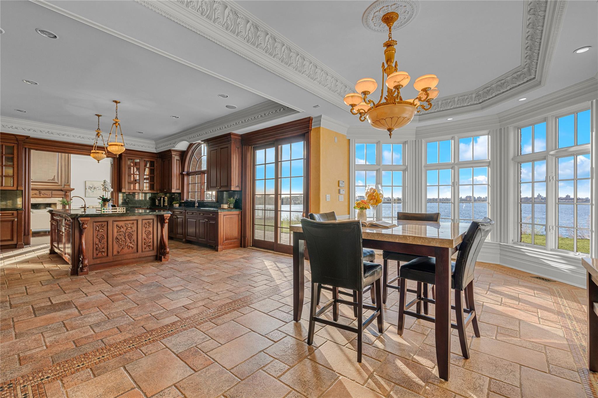 3 Point Crescent Queens, NY 11357 - Photo 17 of 38 Dining space with a chandelier, ornamental molding, stone tile flooring, a water view, and a tray ceiling