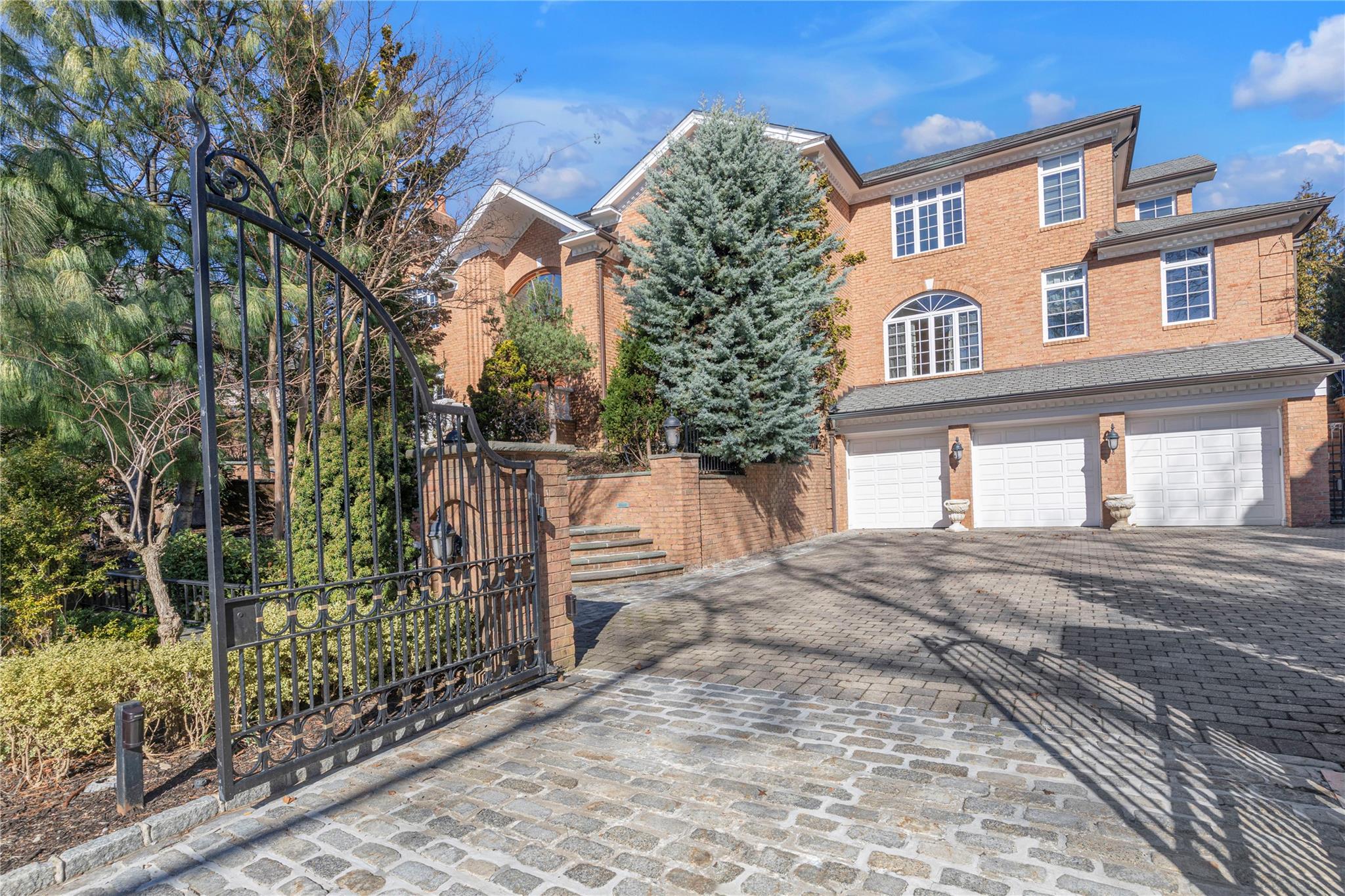 3 Point Crescent Queens, NY 11357 - Photo 2 of 38 View of front of house featuring decorative driveway, a garage, brick siding, and stairs