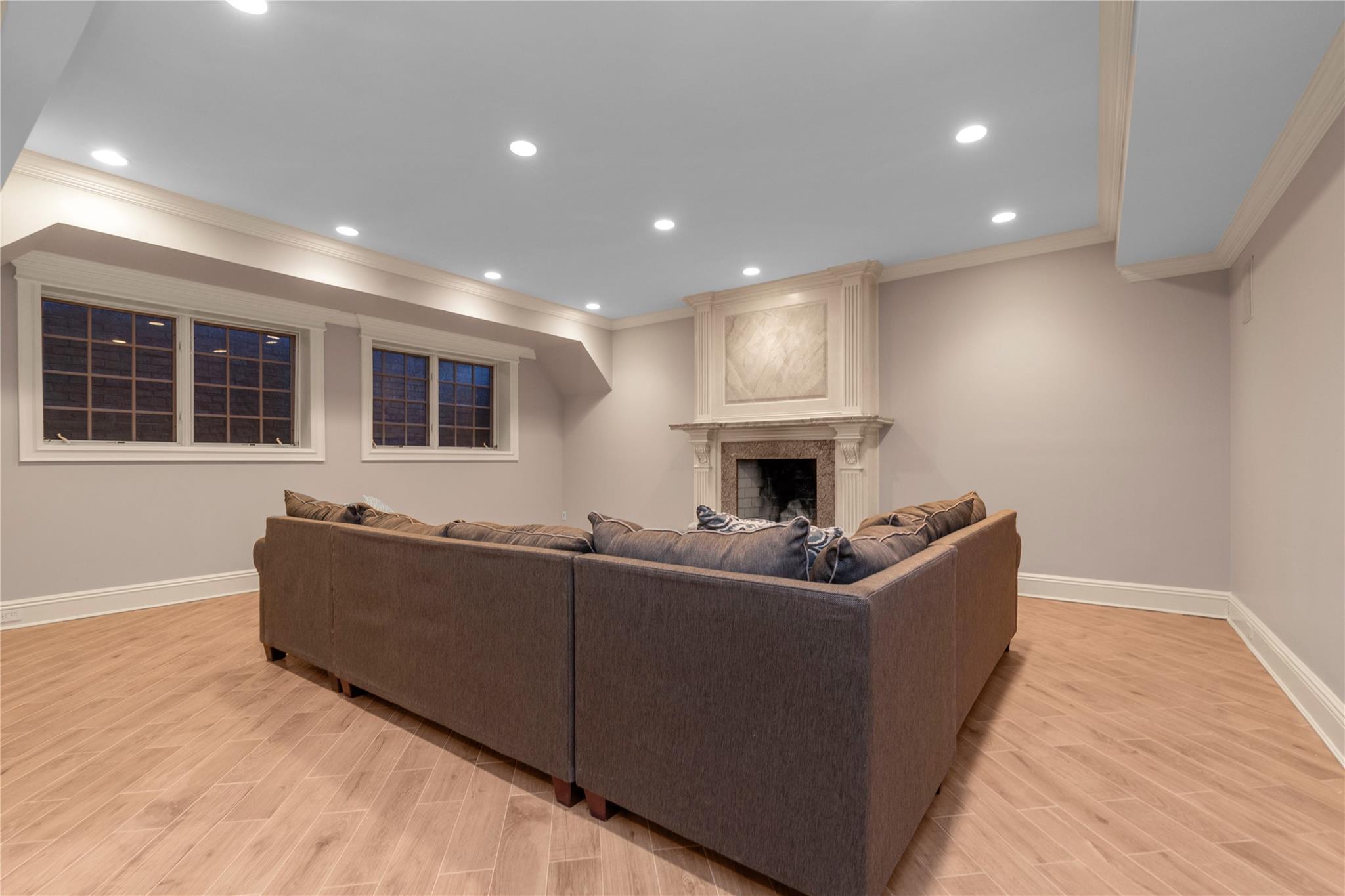3 Point Crescent Queens, NY 11357 - Photo 27 of 38 Living area featuring crown molding, baseboards, light wood-style floors, a large fireplace, and recessed lighting