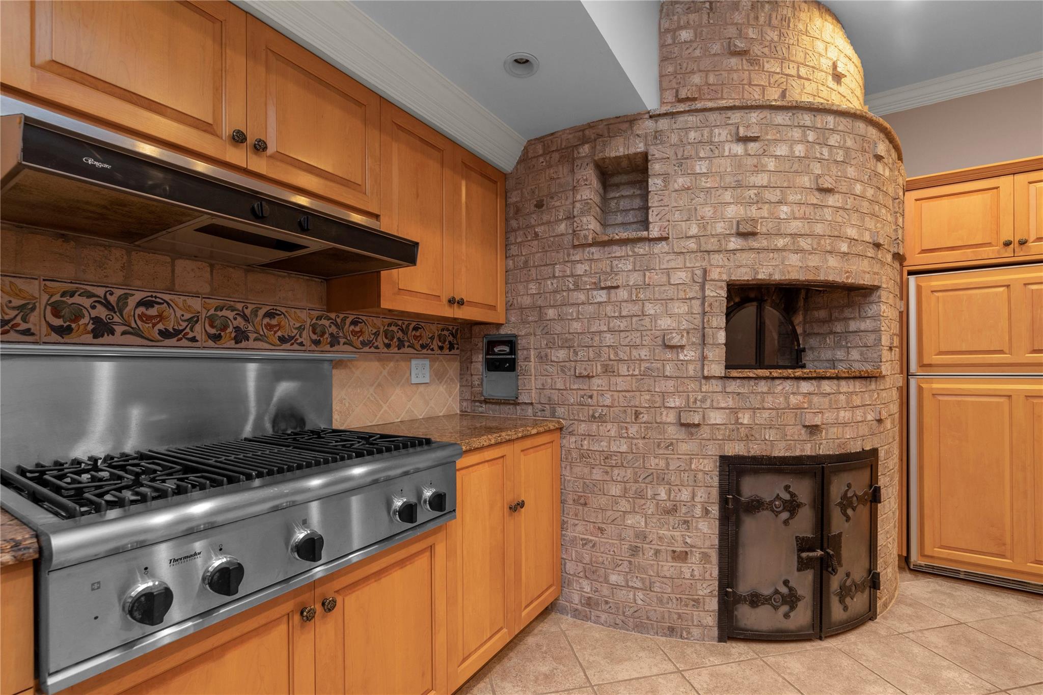 3 Point Crescent Queens, NY 11357 - Photo 28 of 38 Kitchen with stainless steel gas cooktop, crown molding, under cabinet range hood, light tile patterned floors, and tasteful backsplash