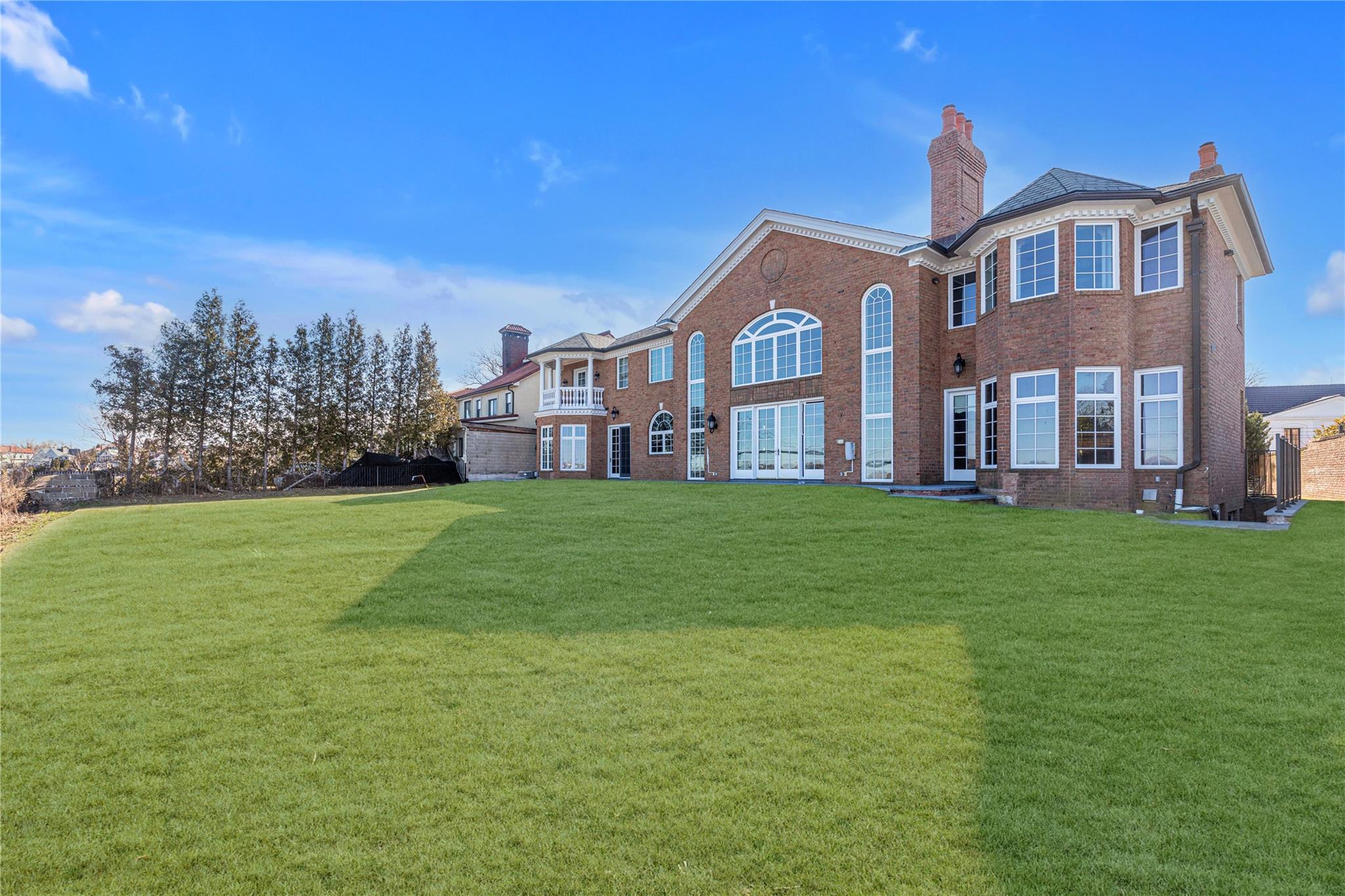 3 Point Crescent Queens, NY 11357 - Photo 32 of 38 Back of house with a chimney, brick siding, and a yard