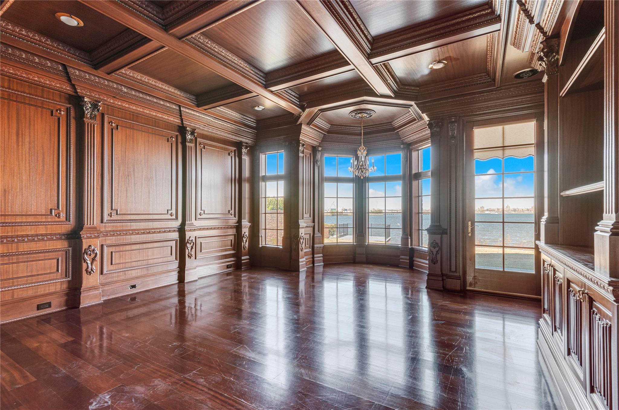 3 Point Crescent Queens, NY 11357 - Photo 9 of 38 Spare room featuring a chandelier, ornamental molding, wood ceiling, decorative columns, and a water view