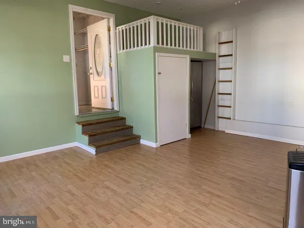 a view of a hallway with entryway wooden floor and front door