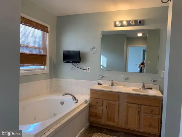 a bathroom with a tub sink and mirror