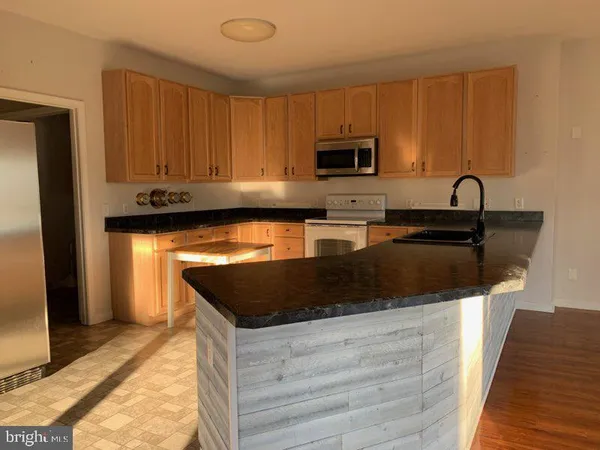 a kitchen with stainless steel appliances granite countertop a sink stove and microwave