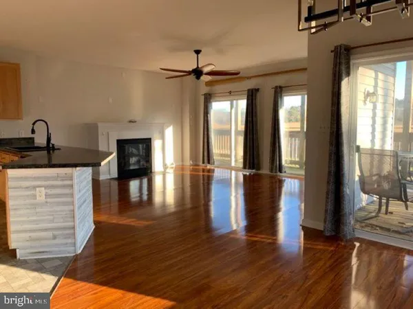 a view of a hallway with wooden floor and a living room