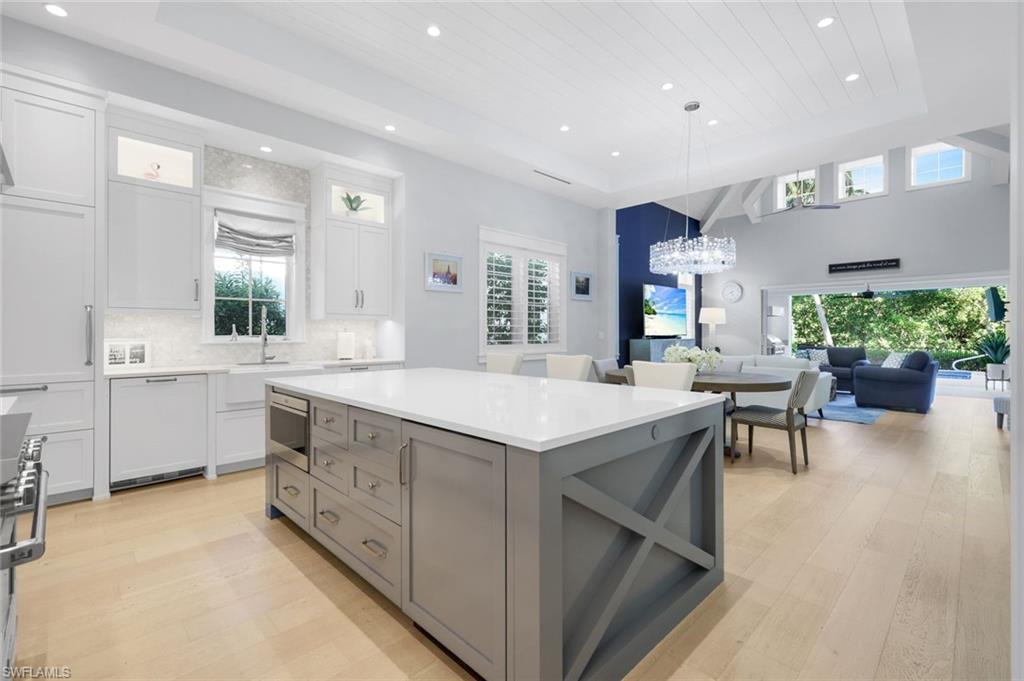 1463 2nd Avenue South Naples, FL 34102 - Photo 12 of 43 a large kitchen with kitchen island a sink a stove a dining table and chairs
