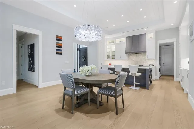 a kitchen with kitchen island a stove a sink a dining table and chairs