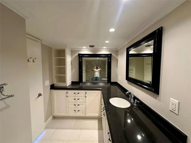 a bathroom with a sink a large mirror and a window