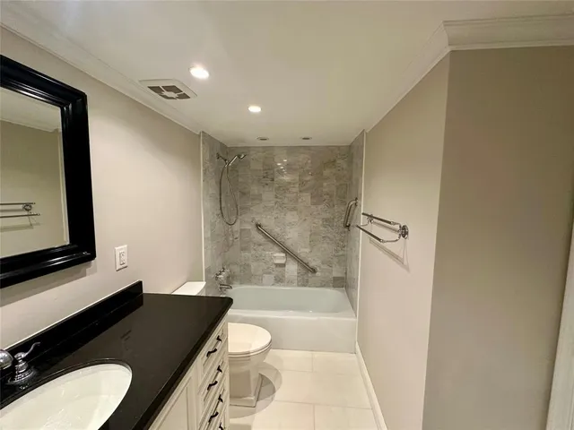 a bathroom with a granite countertop sink a toilet a mirror and shower